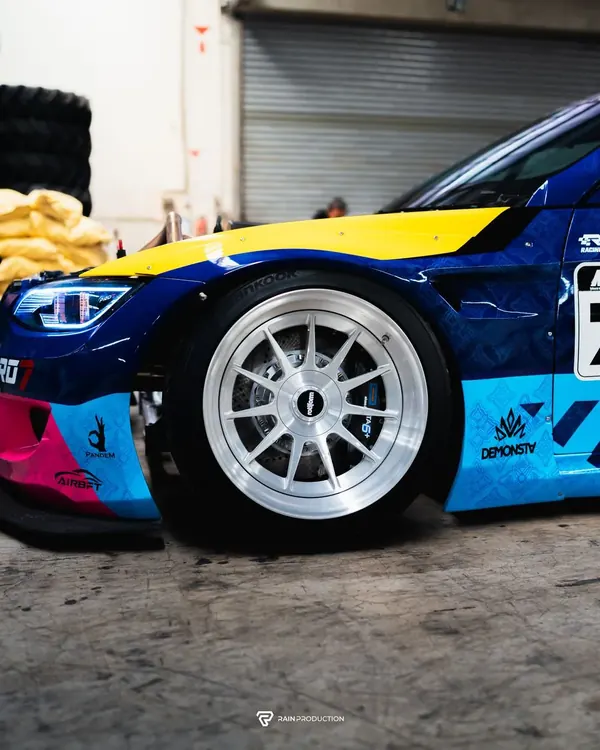 Silver wheel under the wide fender of BMW Passato