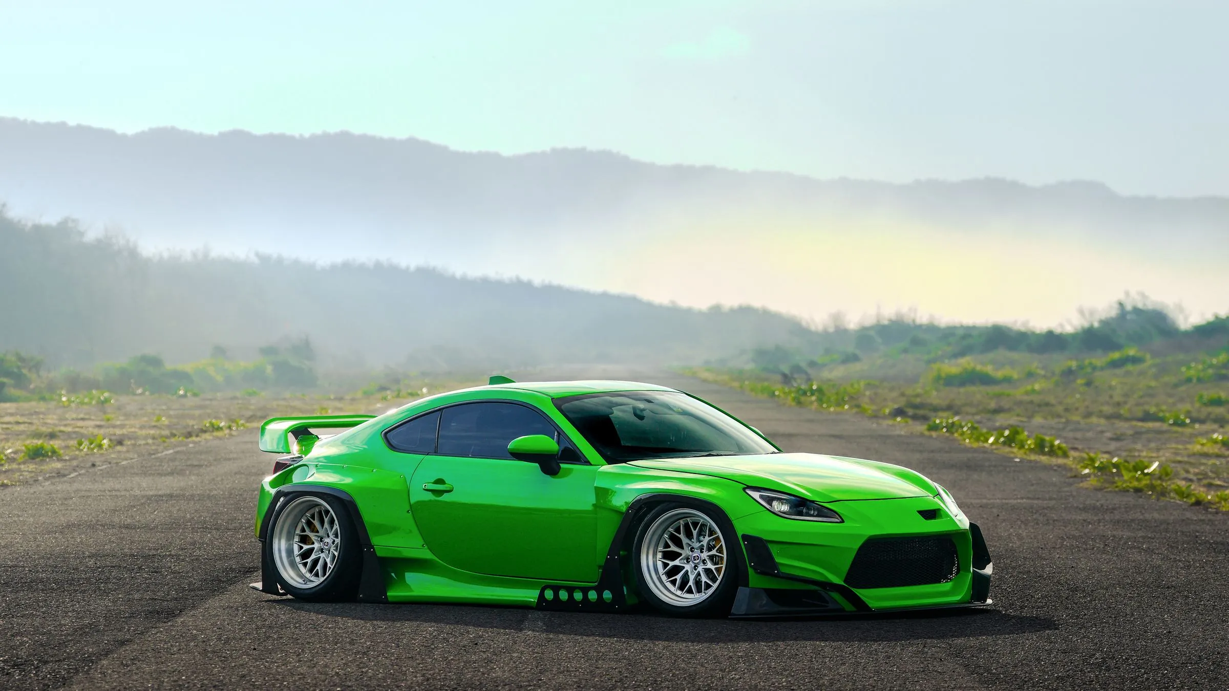 Green GR86 widebody on a misty road