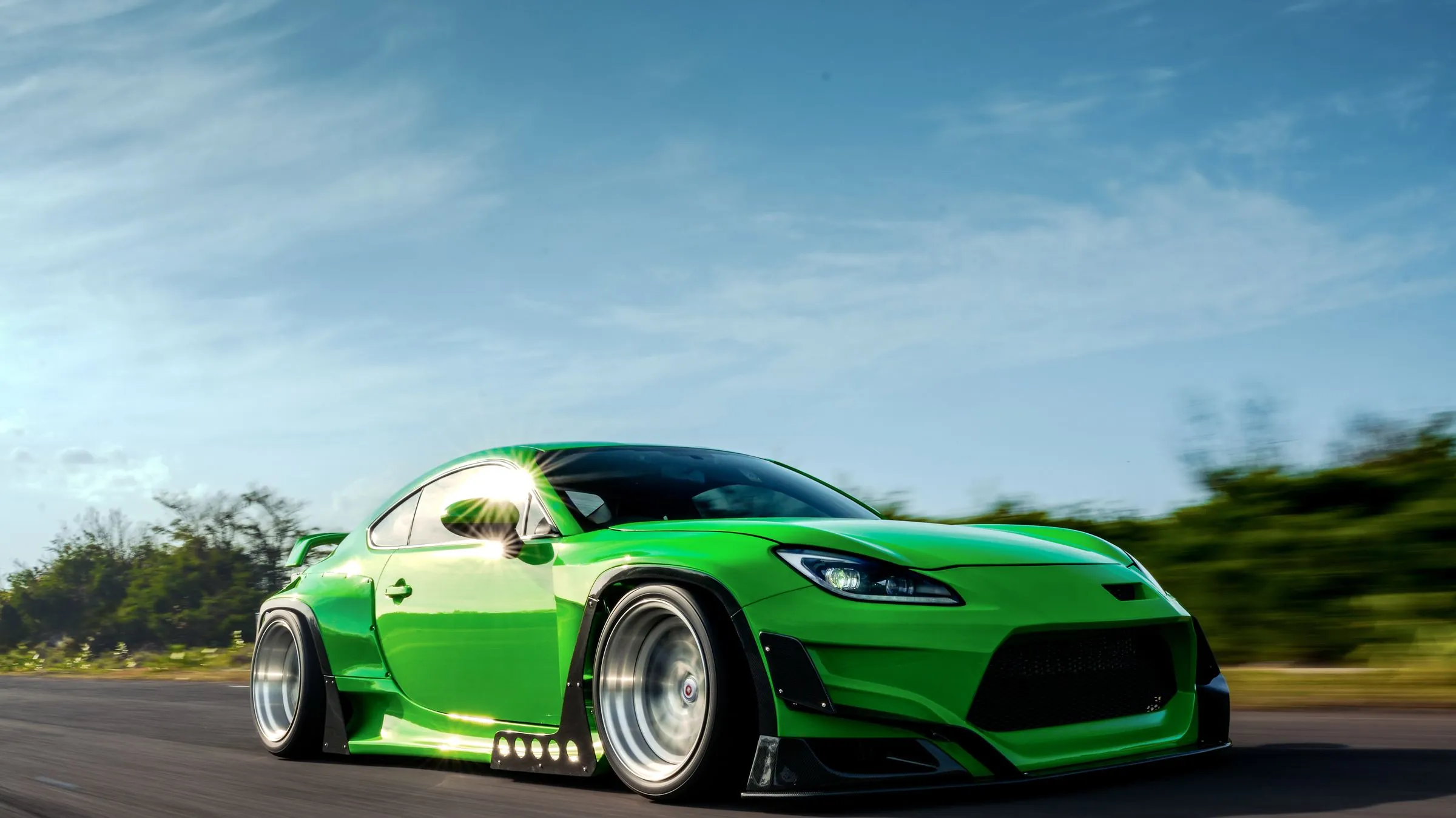 Green widebody on an open road, built by Passato Garage