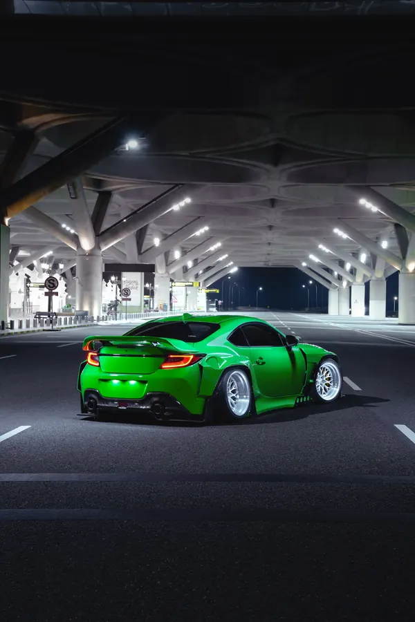 Rear of the GR86 widebody under a lit canopy at night