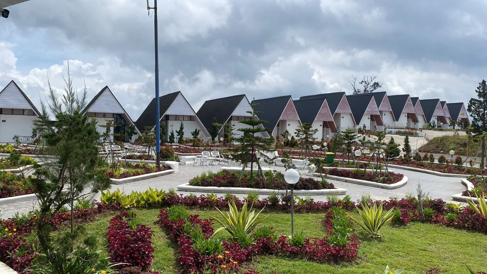 Rows of Cambai Hill A-frame cabins above flower gardens