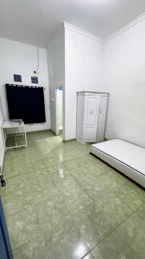 A room with a bed, wardrobe and window curtains