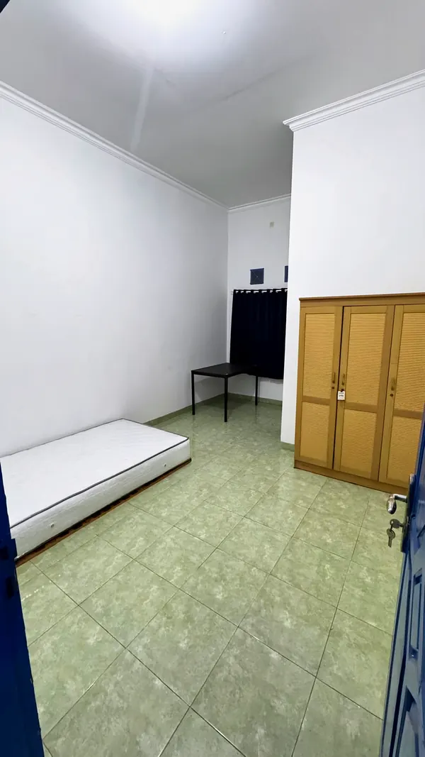 A room with a bed and a wooden wardrobe