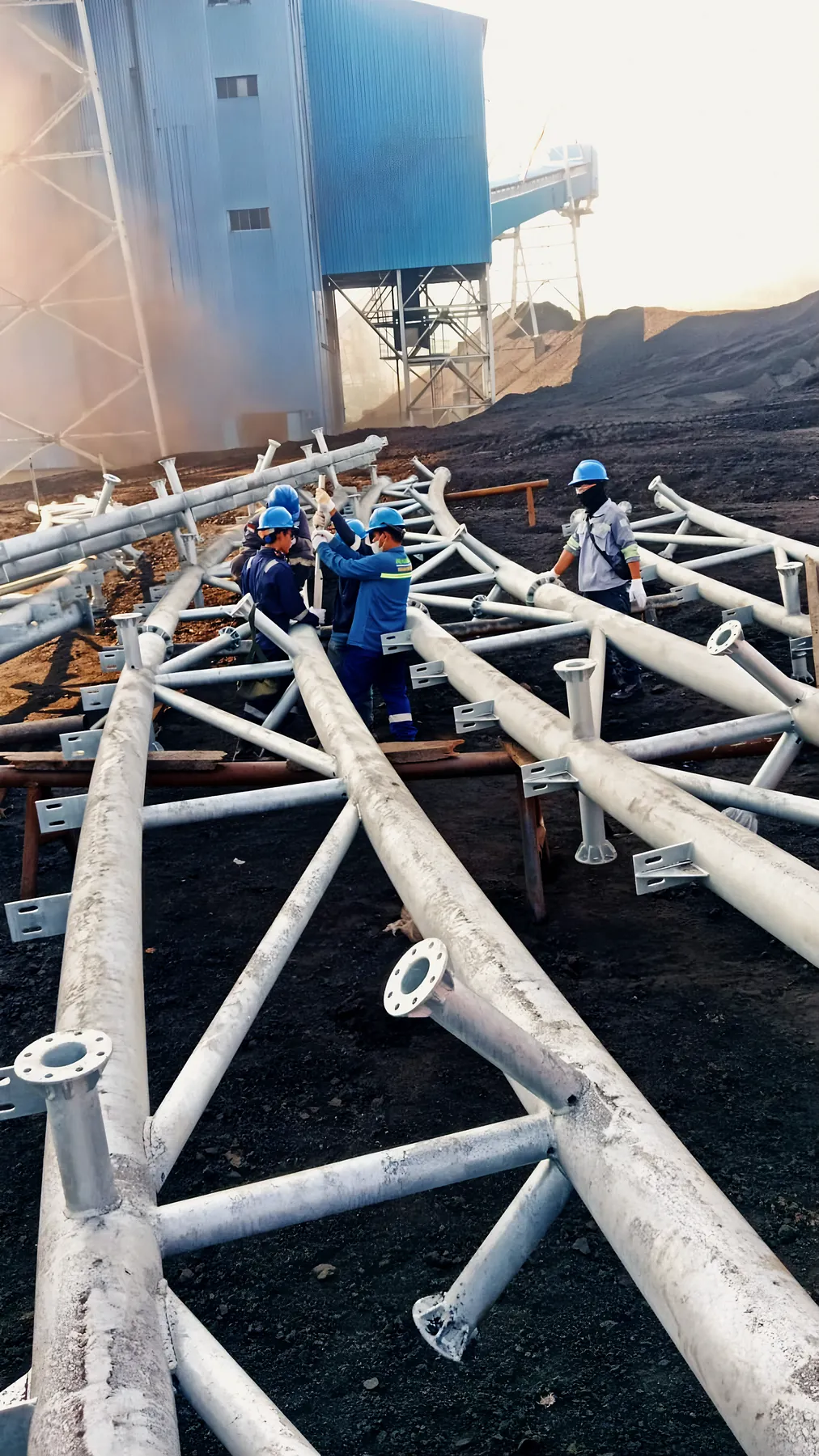 Workers assembling steel trusses on site