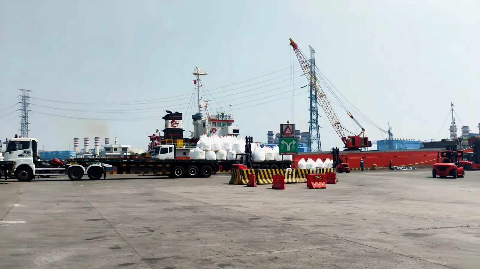 Trailer trucks and bulk bags beside a ship at the port