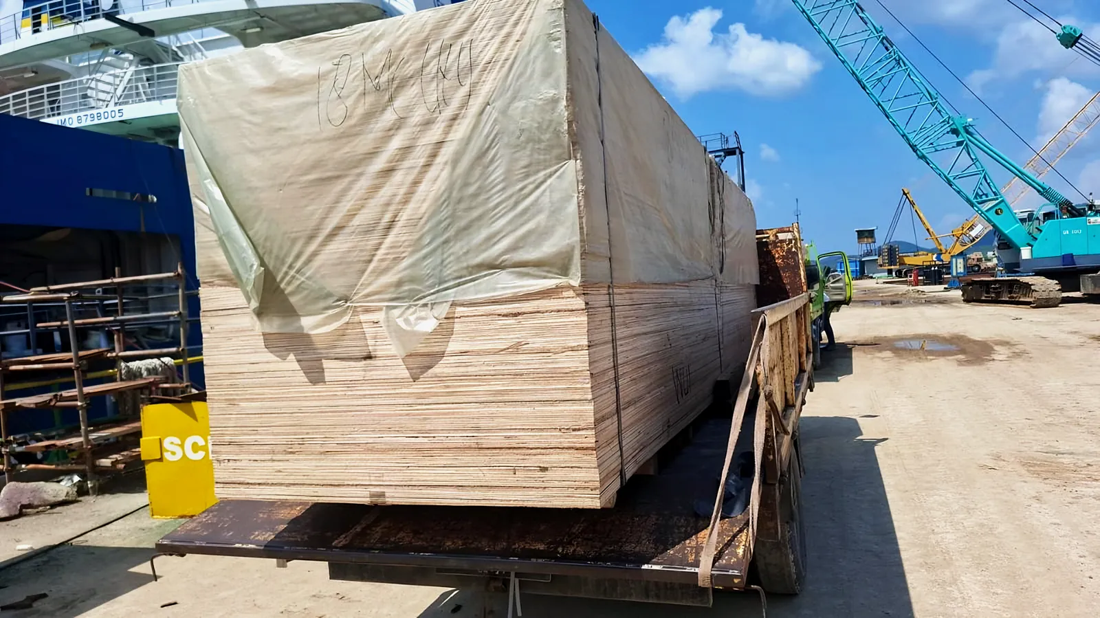 Timber cargo loaded onto a truck beside the ship